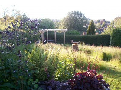  A newly planted Birch draws the eye to the end of the garden and the Downs beyond, in front is set the rustic oak pergola, so veiws