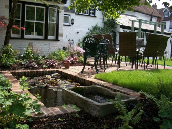 A view over the restored pond to the new terrace in the walled garden Lewes